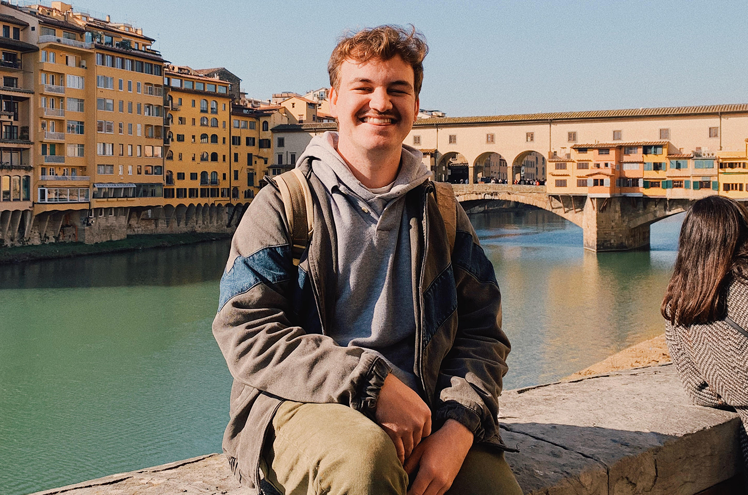 English senior smiling next to a canal in Italy. 