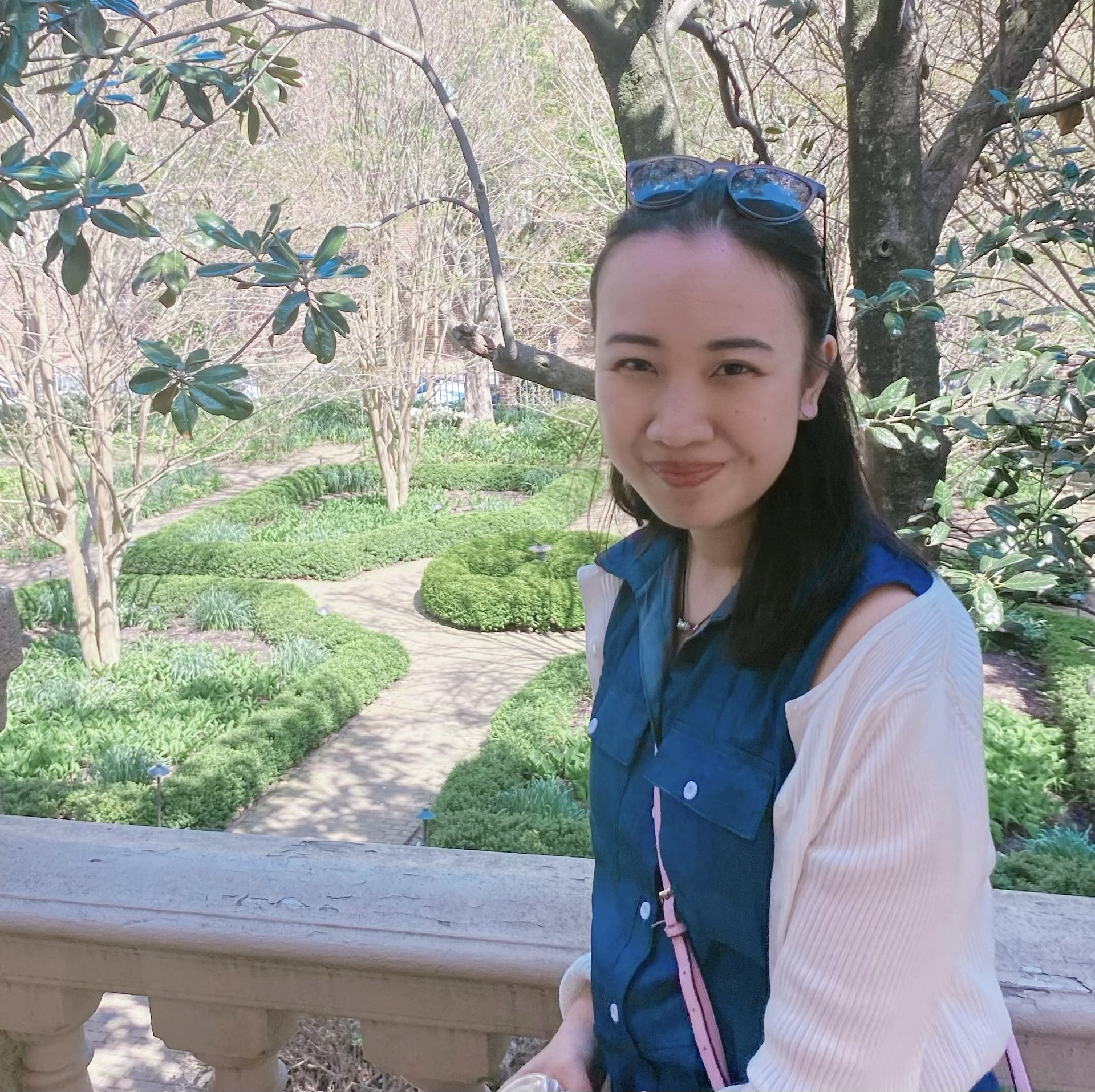 Photo of Carina Jiaxing Shi outdoors with trees and flowers in the background