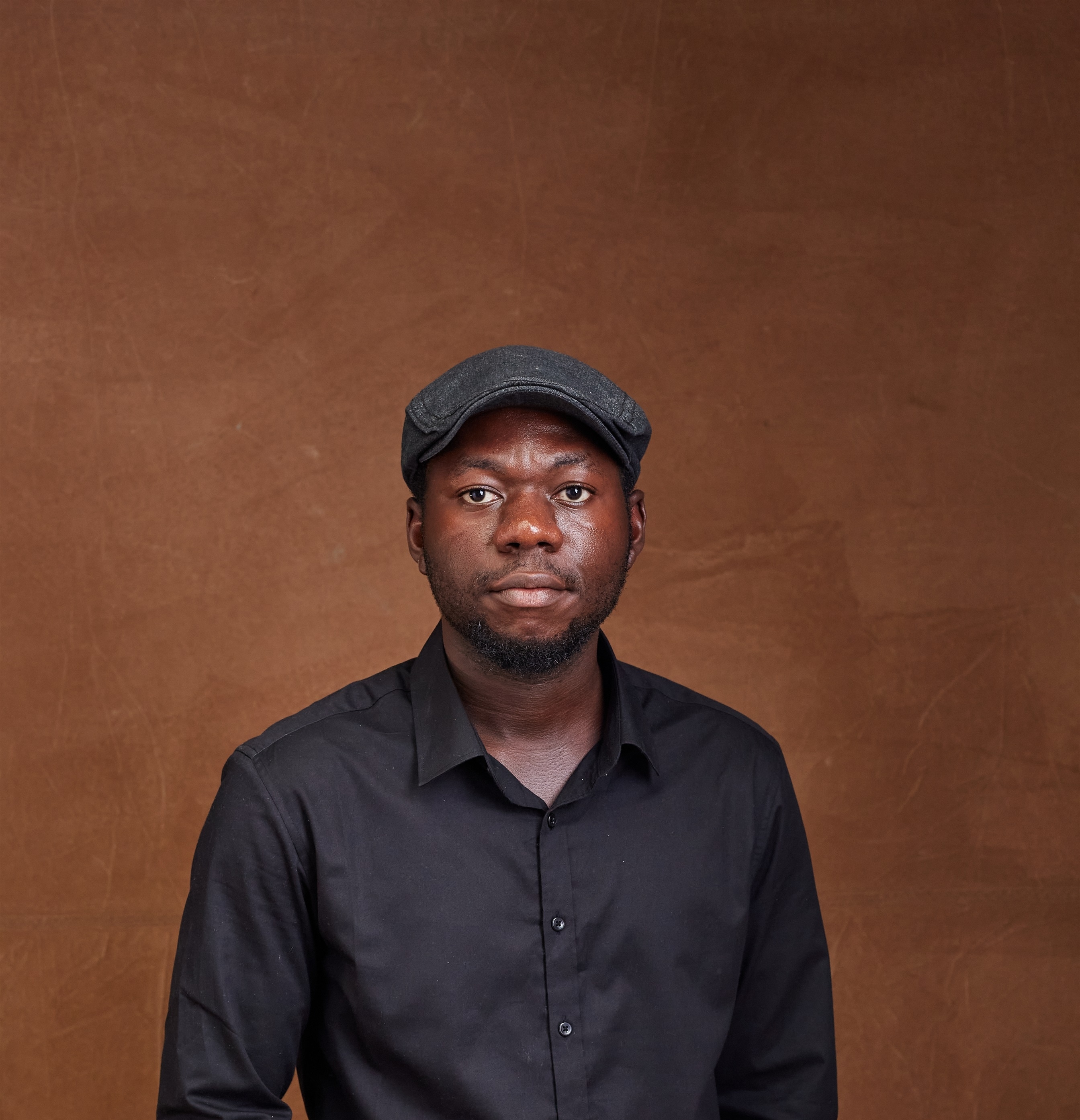 Headshot of Tega Oghenechovwen on brown background