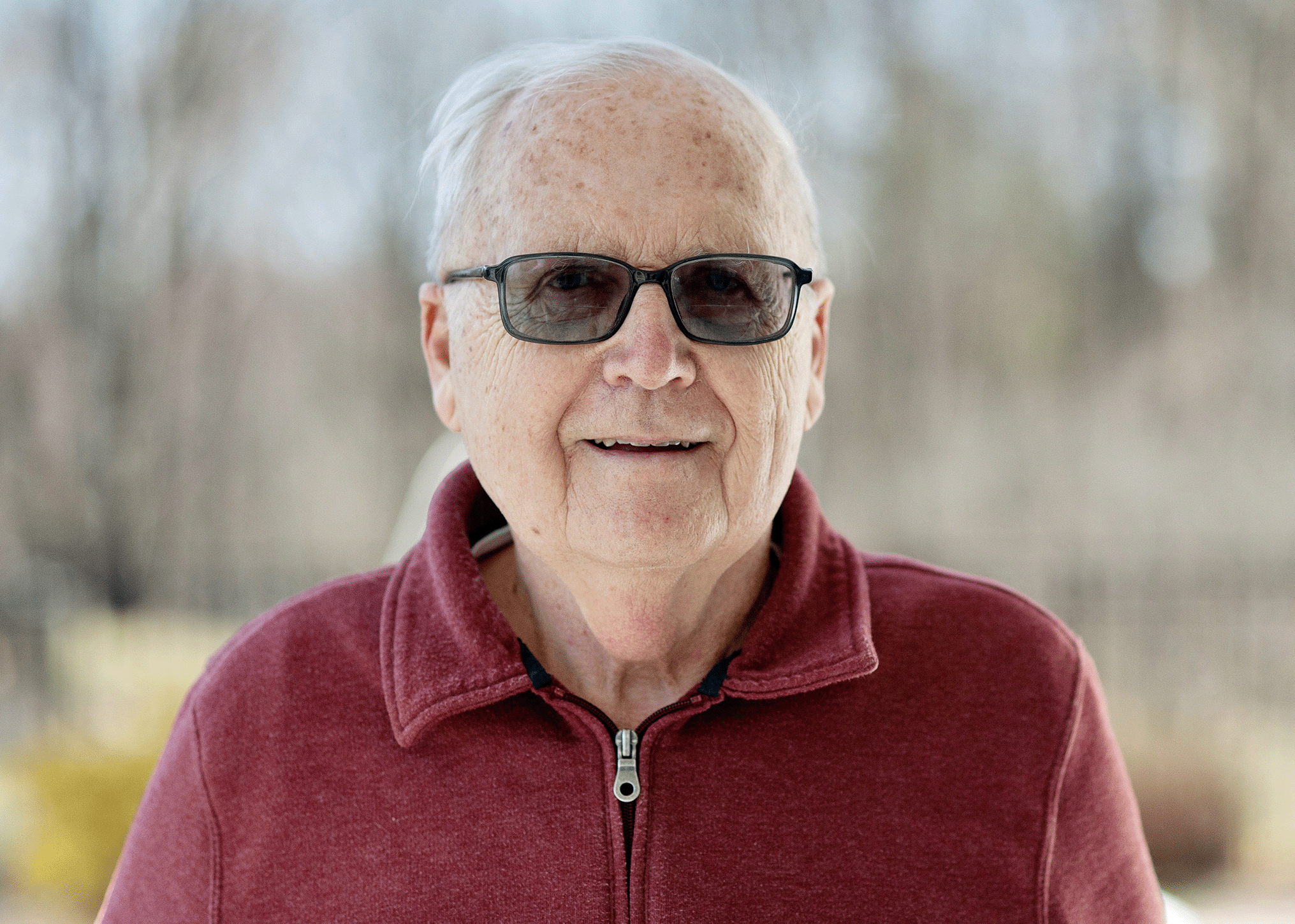 Headshot of Stephen Rojcewicz smiling in sunglasses and a red jacket